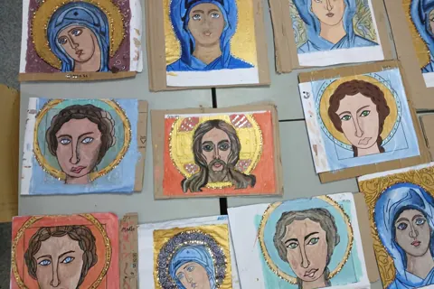 Painted icon portraits on a work table