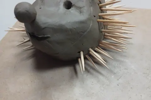 Clay hedgehog sculpture with toothpick spikes
