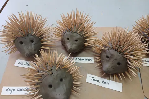 Group of clay hedgehog sculptures with name labels