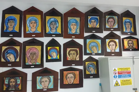Wall display of painted icon-style artworks