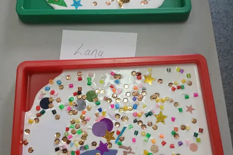 Sparkly collage artworks in red and green trays