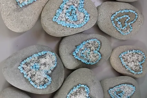 Pebbles decorated with blue and clear heart patterns