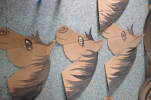 Cardboard horse head drawings on the floor