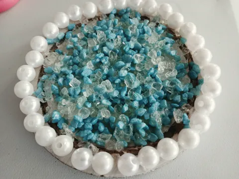 Round blue and clear beaded artwork edged with white pearls