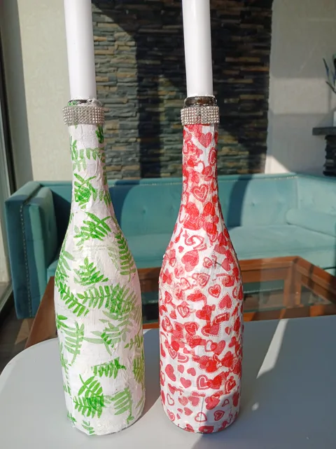 Green and red patterned candle-holder bottles on the studio table