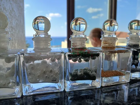 Gem-filled glass jars displayed against the sea-view window