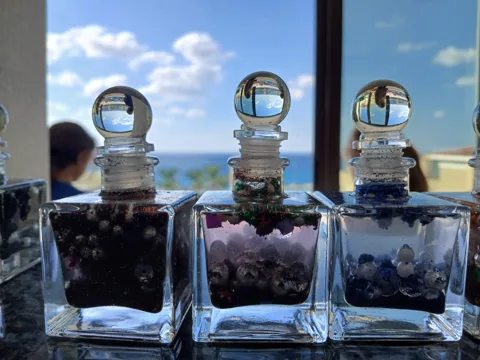 Three blue and purple gem-filled jars decorated with pearls and twine