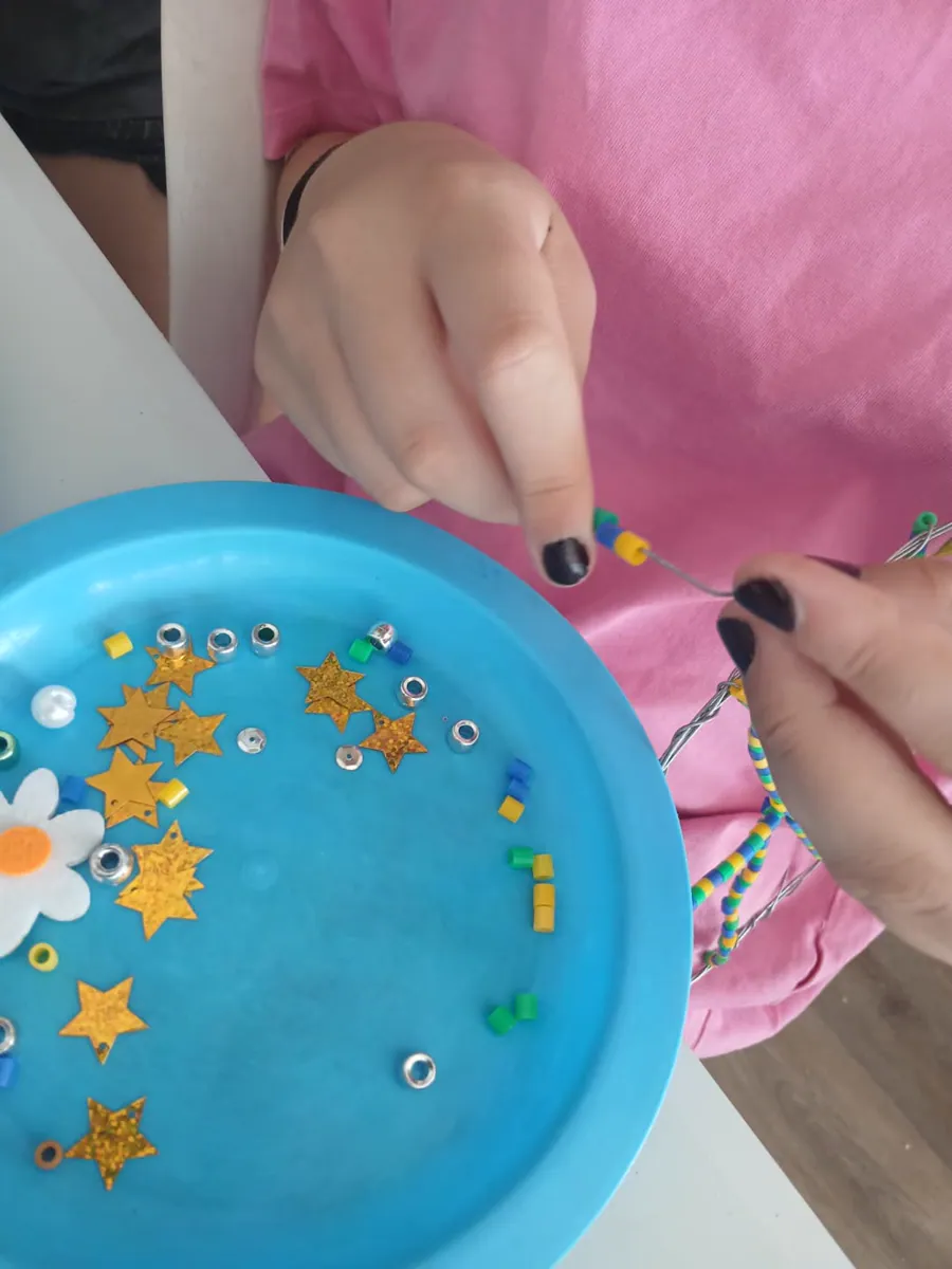 A child choosing colourful beads for a dreamcatcher