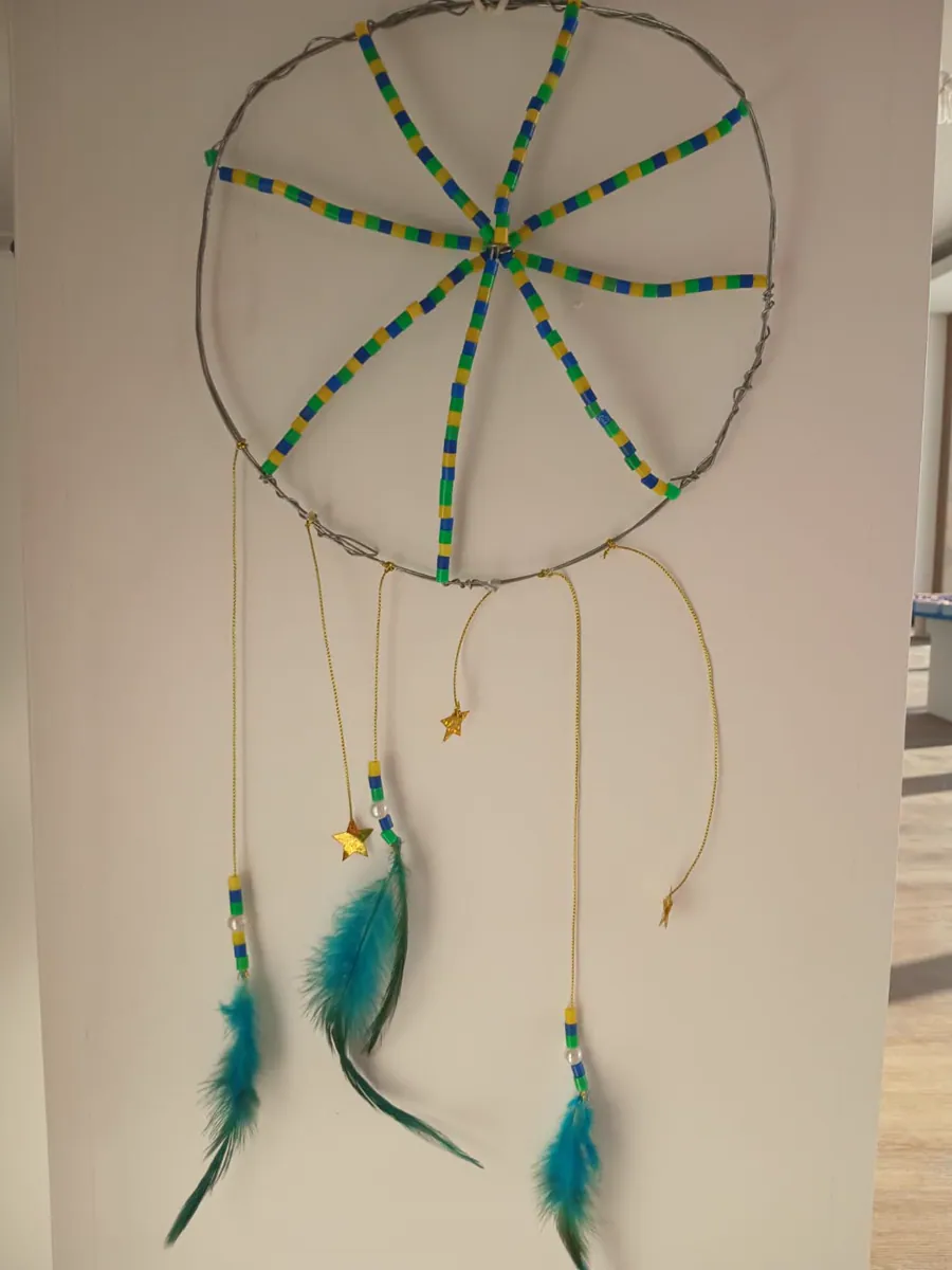 Finished green beaded dreamcatcher with blue feathers