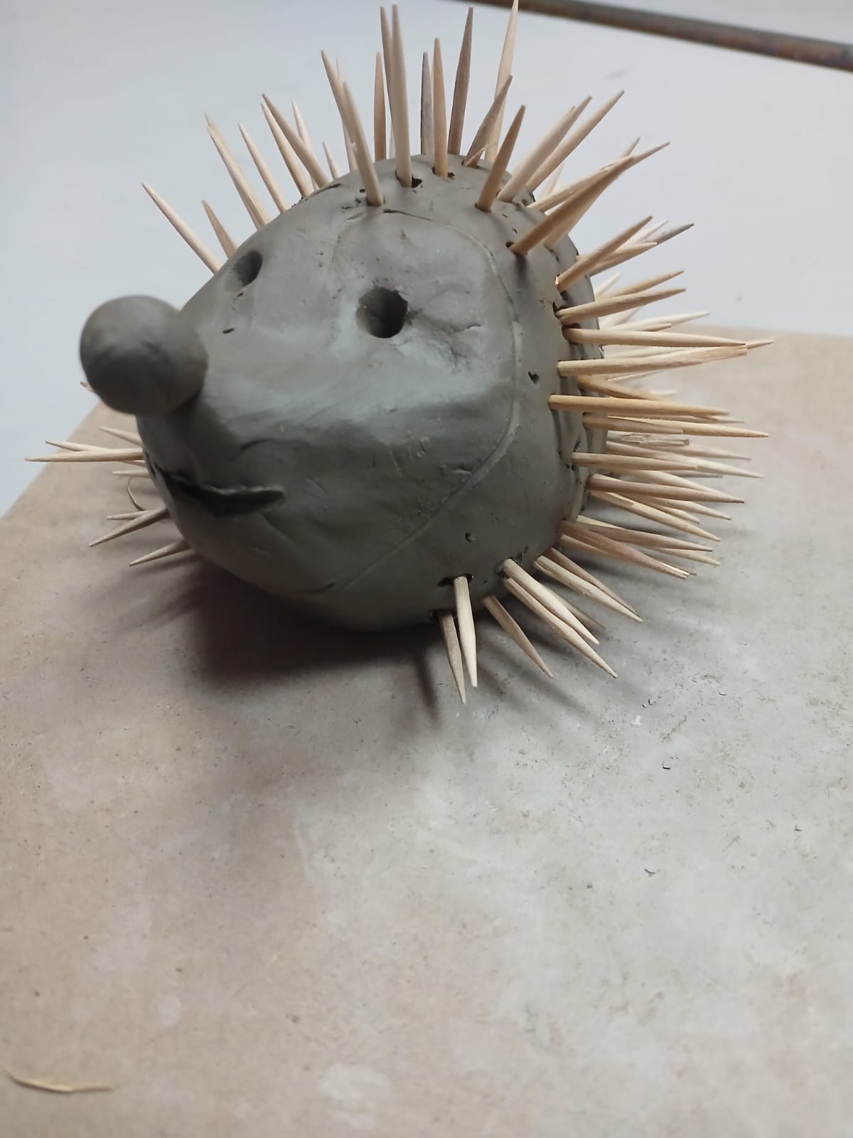 Clay hedgehog sculpture with toothpick spikes