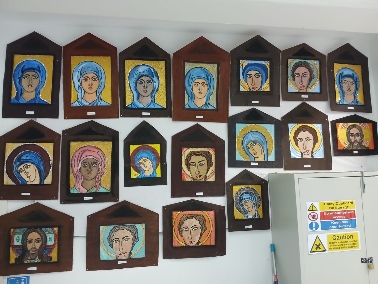 Wall display of painted icon-style artworks