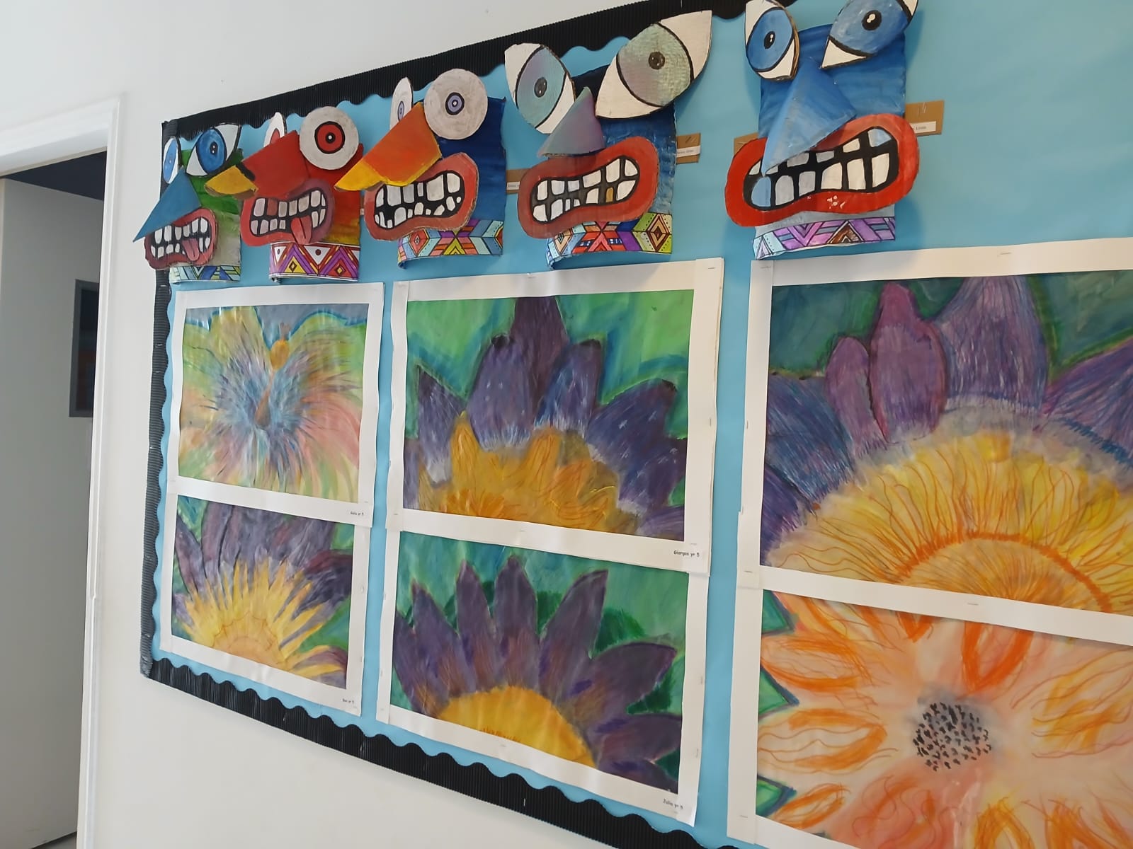 Large flower drawings displayed on a classroom board