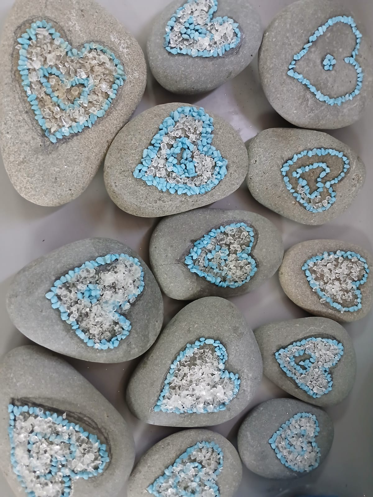Pebbles decorated with blue and clear heart patterns