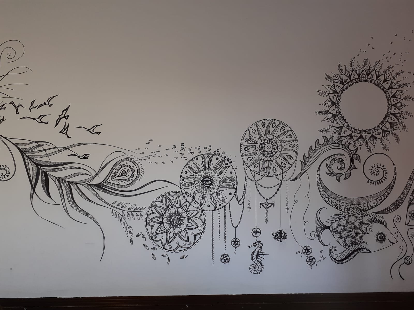 Detailed wall mural section with mandalas, birds and sea shapes