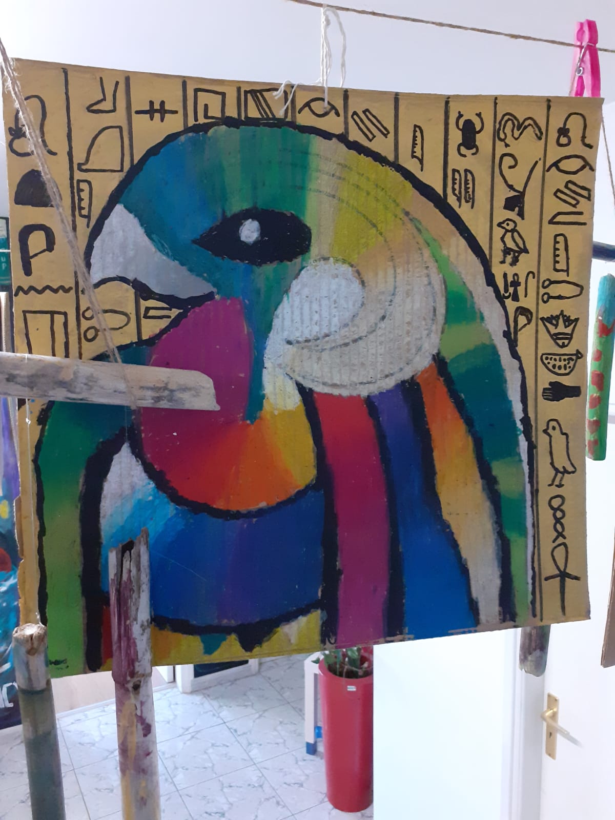Colourful bird artwork on cardboard with symbol markings