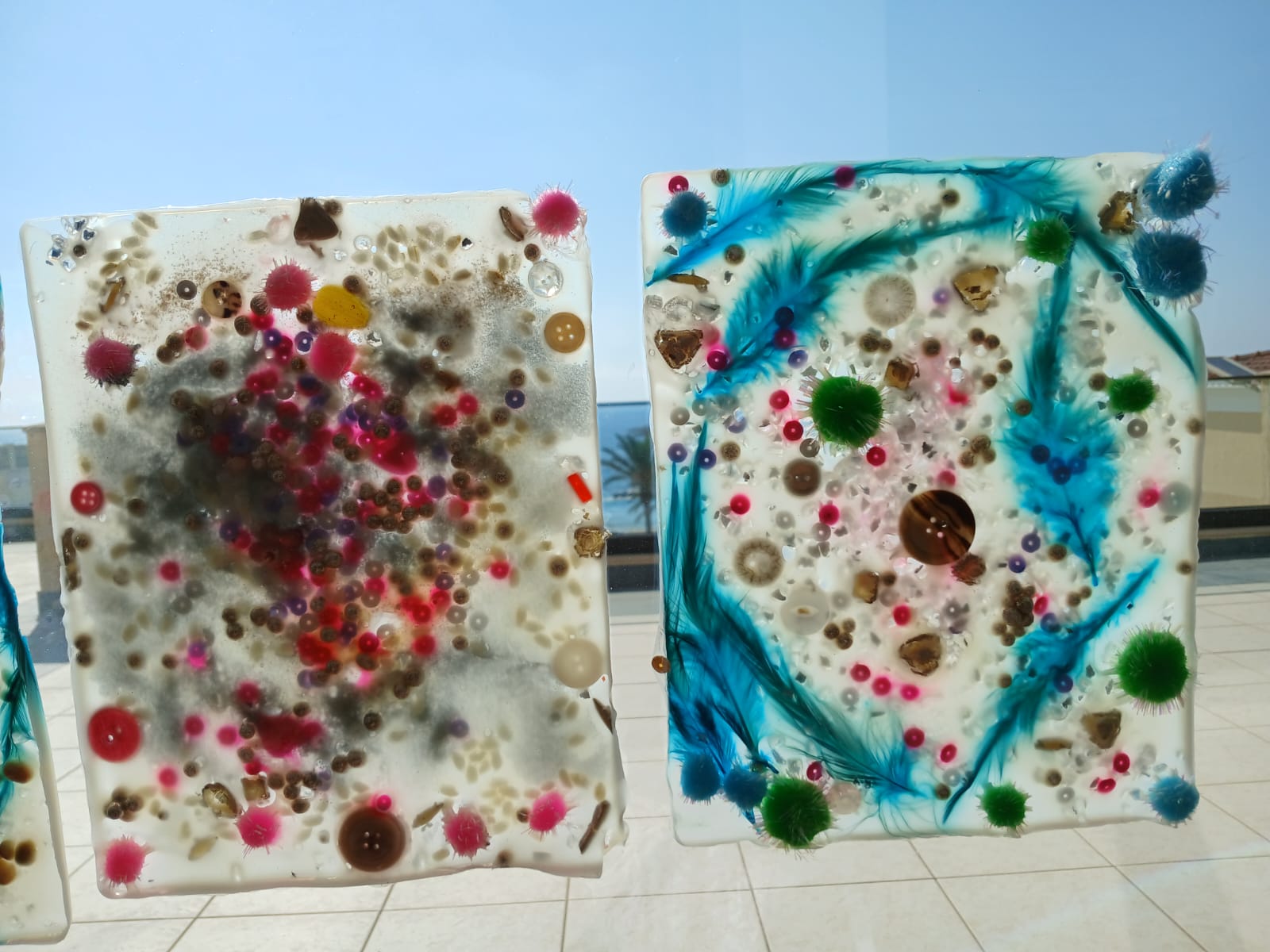 Pair of sensory art panels with beads, feathers and pom-poms