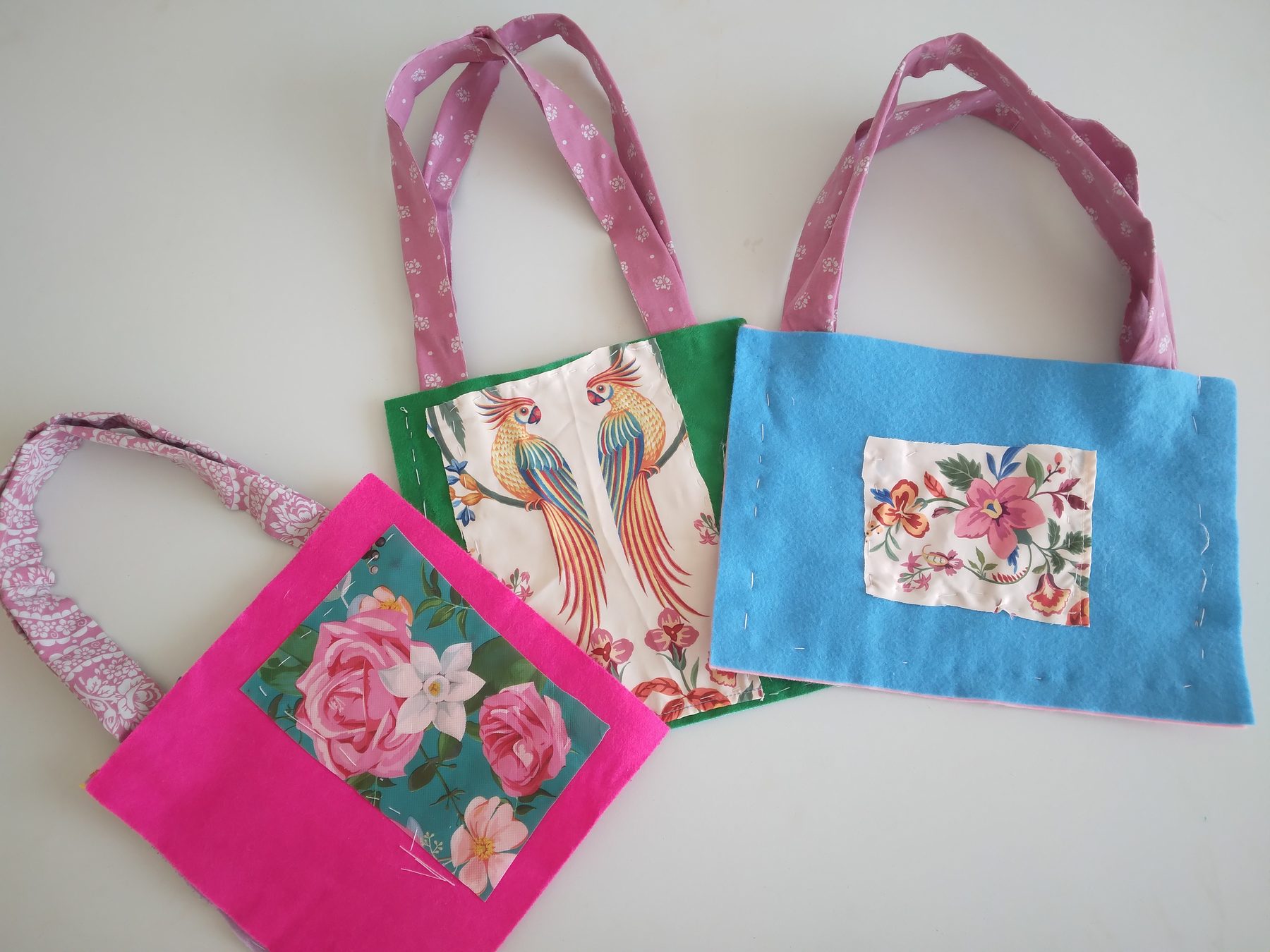 Pink, green and blue handmade fabric bags with patterned panels